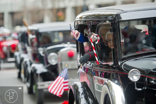 Carson Knight holds a flag out of the window of a Model-T car during the 33rd annual Children's Christmas Parade in Atlanta on Saturday, December 7, 2013. 