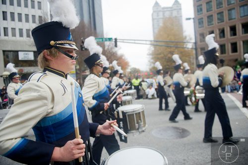 Newnan High School's Dalton Yarbrough (left) plays the snare drum as he marches down Peachtree Street during the 33rd annual Children's Christmas Parade in Atlanta on Saturday, December 7, 2013. 