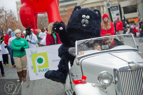 Splat the Cat waves to the crowd as Mark McJunkin and his son Max drive hime down Peachtree Street during the 33rd annual Children's Christmas Parade in Atlanta on Saturday, December 7, 2013.
