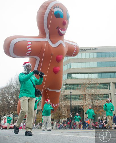 Richard Robinson (left) helps guide a gingerbread man ballon during the 33rd annual Children's Christmas Parade in Atlanta on Saturday, December 7, 2013. 