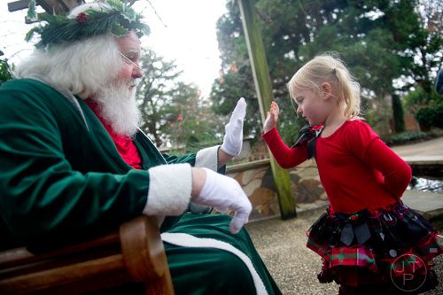 Marin Griffeth gives Santa Claus a high five at the Atlanta Botanical Garden on Saturday, December 7, 2013.