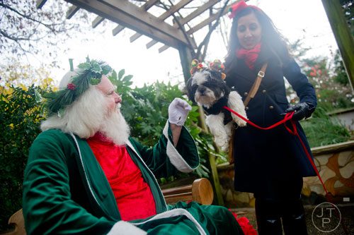 Santa Claus reaches out to pet Moses Cleveland, a shih tzu, as his owner Tamara Feliciano holds him during the Reindog Parade at the Atlanta Botanical Garden in Midtown on Saturday, December 7, 2013. 