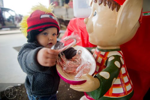 Baylor Steele grabs a candy cane from an elf at Southern Belle Farm in McDonough on Saturday, December 7, 2013.