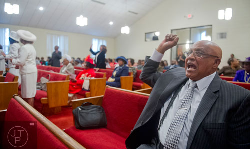 German Jackson throws up his hand in praise during the worship services at Mt. Welcome Missionary Baptist Church in Decatur on Sunday, December 8, 2013.
