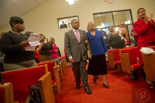 Pastor Darryl Roberts (left) is escorted into the congregation by Carolyn Satcher during the worship services at Mt. Welcome Missionary Baptist Church in Decatur on Sunday, December 8, 2013.
