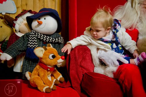 Wren Fry reaches to pet a stuffed Rudolph doll as she visits with Santa at Ronald and Betty Page's home in Canton on Thursday, December 12, 2013.