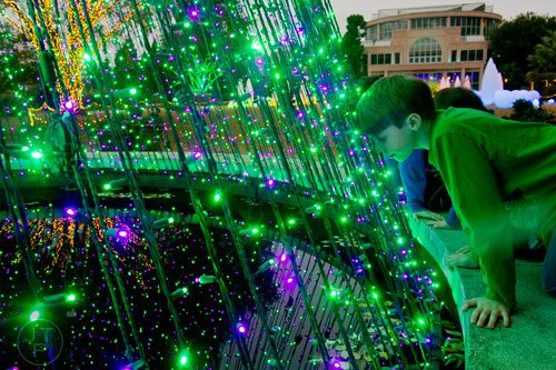 Owen Moriarty (right) leans in to get a closer look at the lights by the fountain during Garden Lights Holiday Nights at the Atlanta Botanical Garden in the Midtown neighborhood of Atlanta on Thursday, November 21, 2013. 