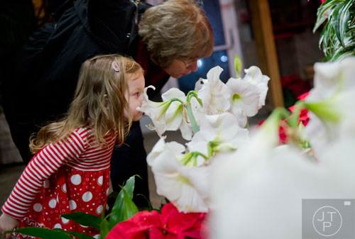 Madison Arnold (left) and Debbie Bloom lean in to smell some of the flowers on display during Garden Lights Holiday Nights at the Atlanta Botanical Garden in the Midtown neighborhood of Atlanta on Thursday, November 21, 2013. 
