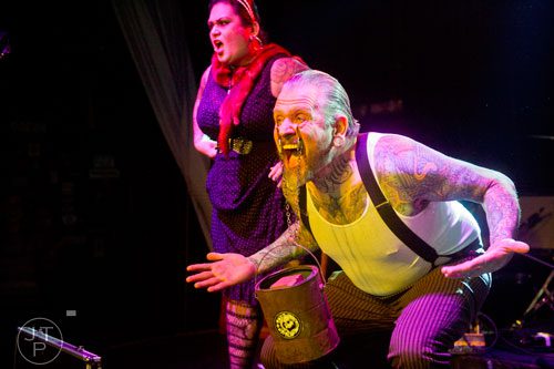 Captain Stab Tuggo (right) hangs a bucket containing a brick from the bottom of his eye lids as he and Maybelle Steele perform on stage at Smith's Olde Bar in Atlanta during Battle of the Beards on Saturday, December 14, 2013. 