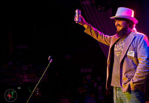 Matt Barlow raises his beer to the crowd as he competes during Battle of the Beards at Smith's Olde Bar in Atlanta on Saturday, December 14, 2013. 