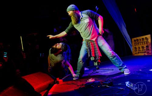 Dustin Waters (right) points to the crowd as John Holloway leans in to try and lick his hand as they compete during Battle of the Beards at Smith's Olde Bar in Atlanta on Saturday, December 14, 2013. 