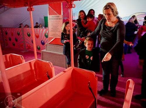 Zander Head (left) and his mother Tiffany pick their seats before riding the Macy's Pink Pig at Lenox Square Mall in the Buckhead neighborhood of Atlanta on Tuesday, November 26, 2013. 