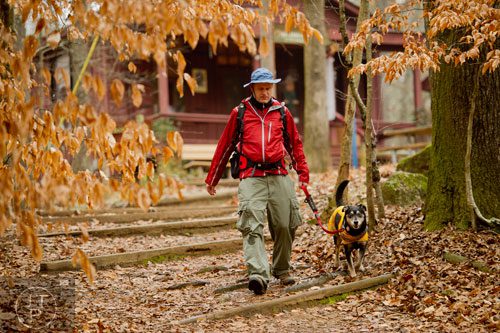 Khris Kramer and his dog Valentine brave the rainy weather as they hike the Homestead Trail at Red Top Mountain State Park in Cartersville on Saturday, December 28, 2013.    