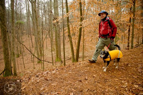 Khris Kramer and his dog Valentine brave the rainy weather as they hike the Homestead Trail at Red Top Mountain State Park in Cartersville on Saturday, December 28, 2013.    