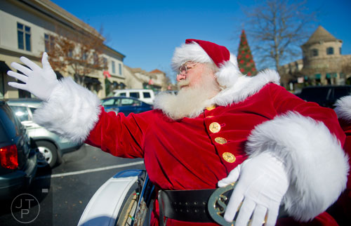 Santa Claus hops a ride on a horse drawn carriage at The Forum in Peachtree Corners on Friday, November 29, 2013.