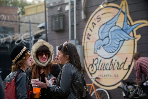 Robin Swinks (left) talks to Jessie Montoro and Kate Schoenke outside of Ria's Bluebird in Atlanta after the funeral for Ria Pell on Saturday, November 30, 2013. 