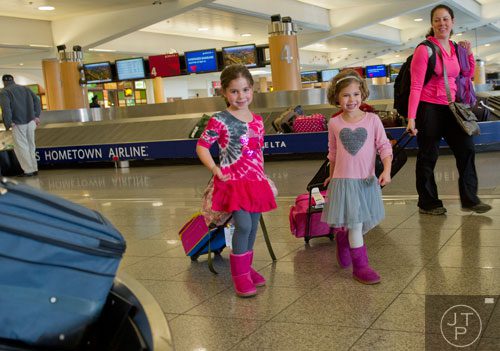 Molly Marcus (left), her sister Annie and mother Peggy carry their bags towards the exit of Hartsfield-Jackson International Airport in Atlanta on Sunday, December 1, 2013. 