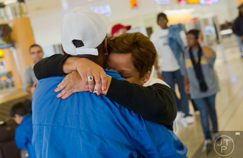 Tammi Sylvester (center) is hugged by her husband Isaac as she walks out of baggage claim at Hartsfield-Jackson International Airport in Atlanta on Sunday, December 1, 2013.   