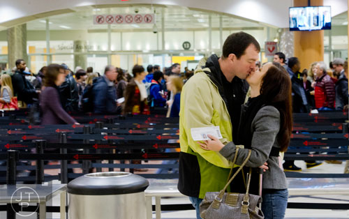 Norm Skakalski (left) kisses his wife Vanessa before she goes through security at Hartsfield-Jackson International Airport in Atlanta on Sunday, December 1, 2013.