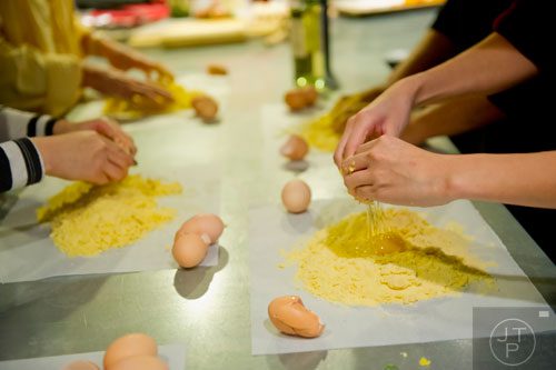 Rachel Shin (right) presses eggs into her dough during the Pastabilities class at The Cooking School at Irwin Street in Atlanta on Saturday, January 18, 2014.   