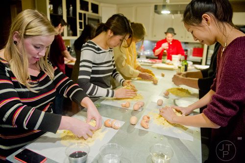 Elisa Gumbel (left) presses eggs into her dough during the Pastabilities class at The Cooking School at Irwin Street in Atlanta on Saturday, January 18, 2014.  