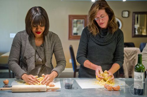 Krista Nelson (left) and Maria James press eggs into their dough during the Pastabilities class at The Cooking School at Irwin Street in Atlanta on Saturday, January 18, 2014. 