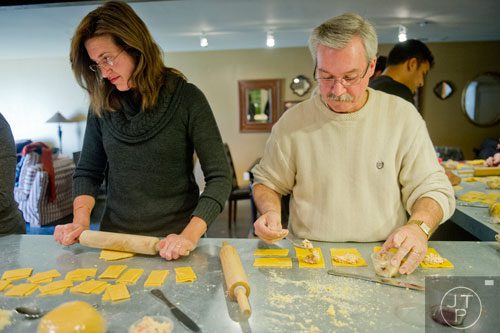 Maria James uses a rolling pin topress her dough as her husband Les fills his ravioli during the Pastabilities class at The Cooking School at Irwin Street in Atlanta on Saturday, January 18, 2014. 