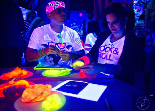 Hawaii Doucet (left) and Alex Quinn play with glow in the dark clay during "Black Light Art" Adult Saturday Night at Zone of Light Studio in Atlanta on Saturday, January 18, 2014. 