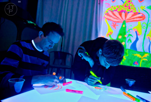 Nicolas Bunzmann (left) and Kyle Bulkley use highlighters to draw during "Black Light Art" Adult Saturday Night at Zone of Light Studio in Atlanta on Saturday, January 18, 2014. 