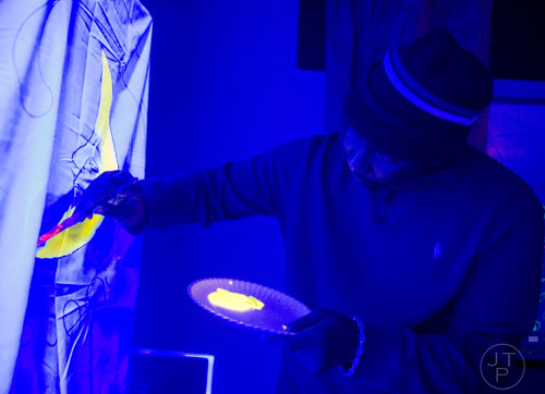 Joseph Adair paints on a sheet during "Black Light Art" Adult Saturday Night at Zone of Light Studio in Atlanta on Saturday, January 18, 2014. 
