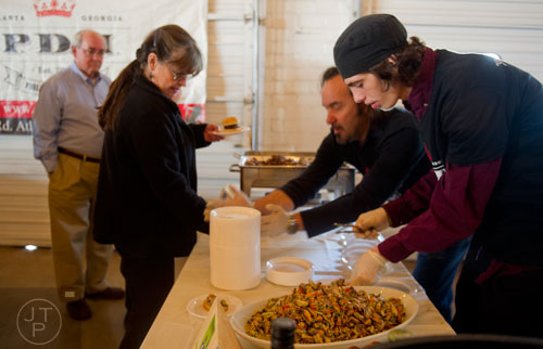 Chaz Turner (right) prepares a plate of food for Deborah Philips to taste during the Great Southern Craft Beer Competition Kickoff Party at Monday Night Brewing in Atlanta on Sunday, January 19, 2014.