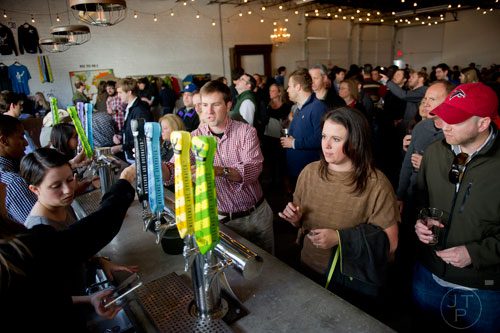 Susan Echterhoff (right) and Bobby Courage stands in line to taste beer during the Great Southern Craft Beer Competition Kickoff Party at Monday Night Brewing in Atlanta on Sunday, January 19, 2014.