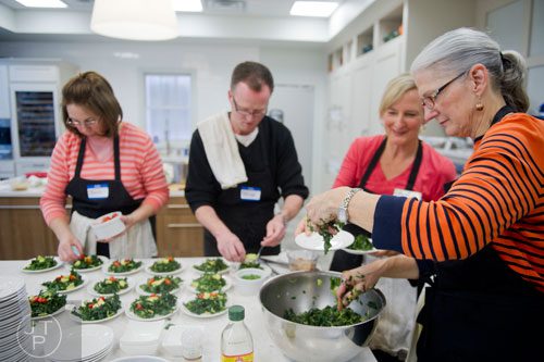 Theresa Mitchell (right), Patricia Cummings, Brian Benefield and Barb Fry help Chef MJ Conboy plate massaged kale and brussel sprout salad during the Exploring a Plant-Based Diet class at the Cook's Warehouse in Marietta on Tuesday, January 21, 2014. 