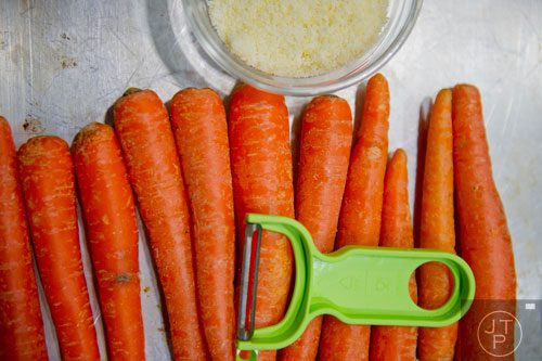 Carrots, a peeler and a bowl of parmesan cheese sit on a tray during a cooking class at the Salud Cooking School at Harry's Farmers Market in Roswell on Thursday, January 23, 2014.