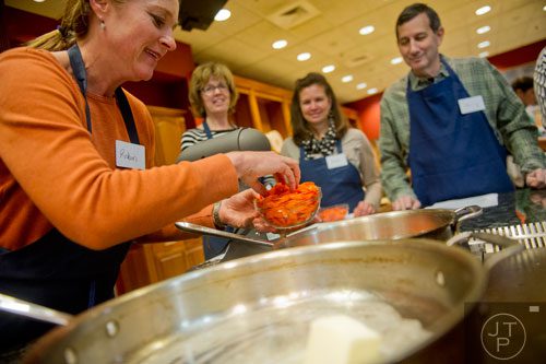 Robin Heim (left) places carrot slices into a pan during a cooking class at the Salud Cooking School at Harry's Farmers Market in Roswell on Thursday, January 23, 2014.