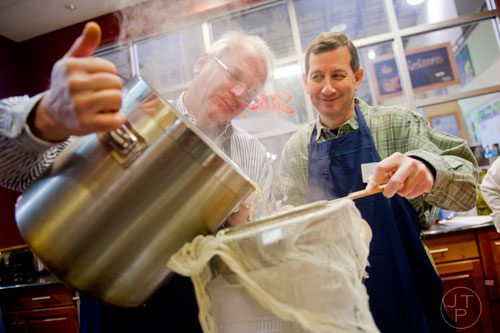 Skip Heim (left) pours beef broth into a container as Henry Abelman holds the strainer steady during a cooking class at the Salud Cooking School at Harry's Farmers Market in Roswell on Thursday, January 23, 2014.  