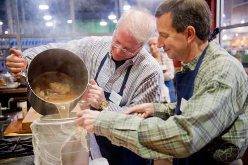 Skip Heim (left) pours beef broth into a container as Henry Abelman holds the strainer steady during a cooking class at the Salud Cooking School at Harry's Farmers Market in Roswell on Thursday, January 23, 2014. 