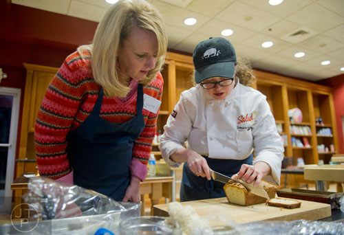 Laurel Mackenzie (left) watches as Chef Samantha Enzmann demonstrates how to make the proper way to slice a pound cake to fill a zuccotto during a cooking class at the Salud Cooking School at Harry's Farmers Market in Roswell on Thursday, January 23, 2014. 