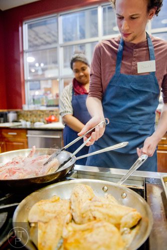 Daniel McAlonan (right) flips chicken quarters in a pan as Supriya Shridharan watches during a cooking class at the Salud Cooking School at Harry's Farmers Market in Roswell on Thursday, January 23, 2014. 