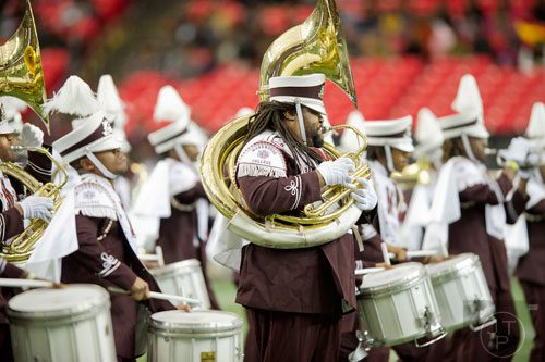 Morehouse College's Nigel Burnett (center) marches while playing the tuba during the 2014 Honda Battle of the Bands at the Georgia Dome in Atlanta on Saturday, January 25, 2014. 