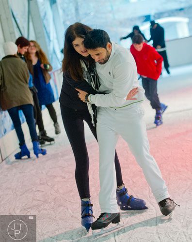 Susann Gulen (left) catches her husband Burak as he falls towards the floor of the rink as they ice skate at Centennial Olympic Park in downtown Atlanta on Sunday, December 8, 2013. 
