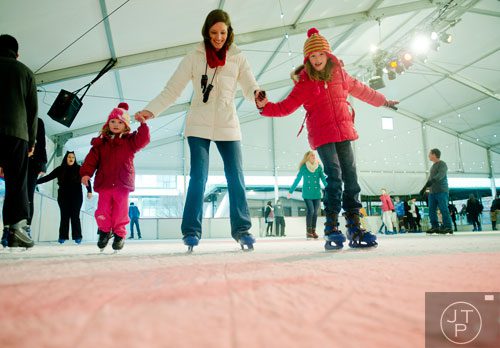 Jenny Clay (center) ice skates with her daughter Libby (left) and niece Hayden Wood  at Centennial Olympic Park in downtown Atlanta on Sunday, December 8, 2013.  