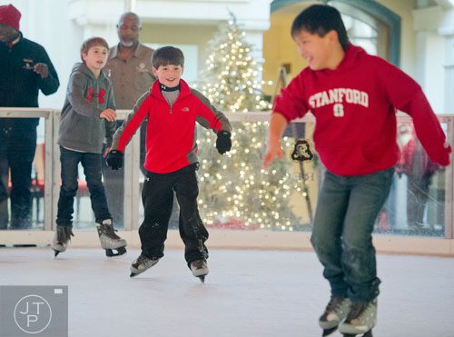 Fin Regal (center) chases after James Rhee as they ice skate at the St. Regis in Buckhead on Wednesday, December 18, 2013. 