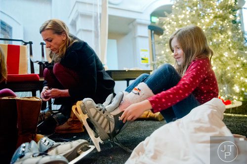 Lilly Taylor (right) puts on ice skates as her aunt Erin Felentzer helps her sister at the St. Regis in Buckhead on Wednesday, December 18, 2013. 