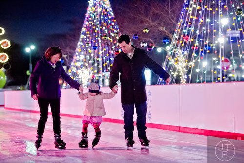 Jennifer Owens (left) ice skates with her daughter Ellie and husband Colin at Atlantic Station in Midtown on Thursday, December 19, 2013. 