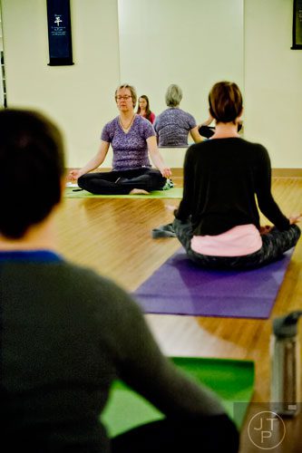 Instructor Cherri McCallister (left) leads her yoga class in a breathing exercise at Breathe Yoga in Chamblee on Monday, January 6, 2014.