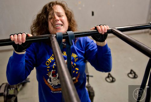 Kelly Norton pulls her chin over the bar as she works out at Operation CrossFit in Alpharetta on Wednesday, January 8, 2014. 