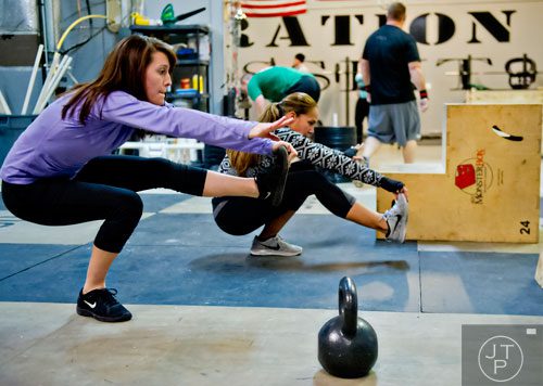 Carrie Blackwell (left) and Heather Barr work out at Operation CrossFit in Alpharetta on Wednesday, January 8, 2014. 