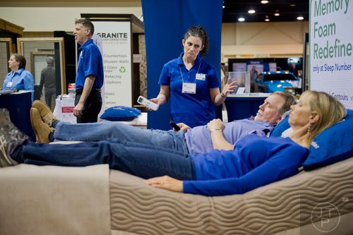 Stuart Wilson (center) and his wife Joyce lay on a display bed as they talk with Lauren Smoller at the North Atlanta Home Show at the Gwinnett Center in Duluth on Sunday, February 23, 2014. 