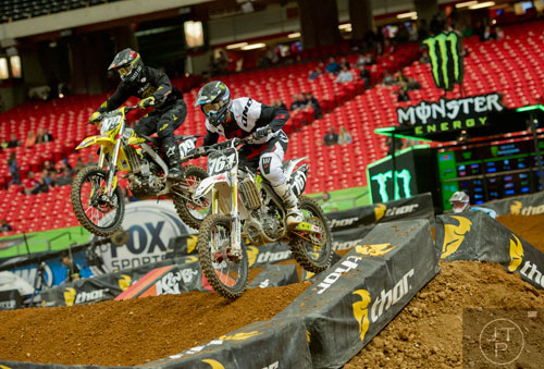 Cade Clason (761) and Augie Lieber (879) catch some air as they compete in a qualifying round of the Monster Energy AMA Supercross FMI World Championship at the Georgia Dome in Atlanta on Saturday, February 22, 2014. 